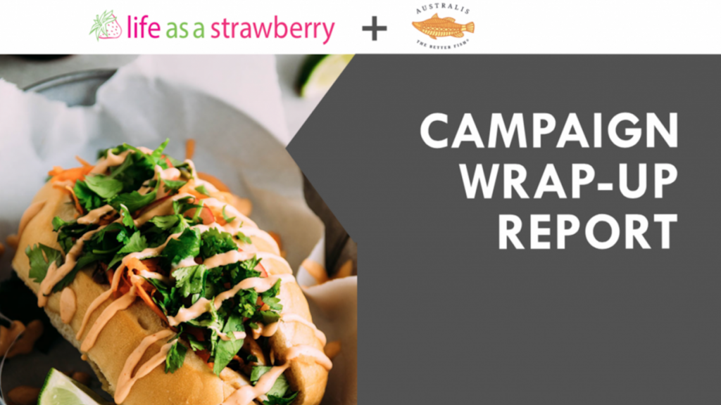 Life As A Strawberry and Australis Logo. Sandwich bun on a black paper lined plate filled with cilantro, carrots, and fish, drizzled with redish sauce. Hand squeezing lemon wedge over barramundi and tomatoes. Text Campaign wrap-up report